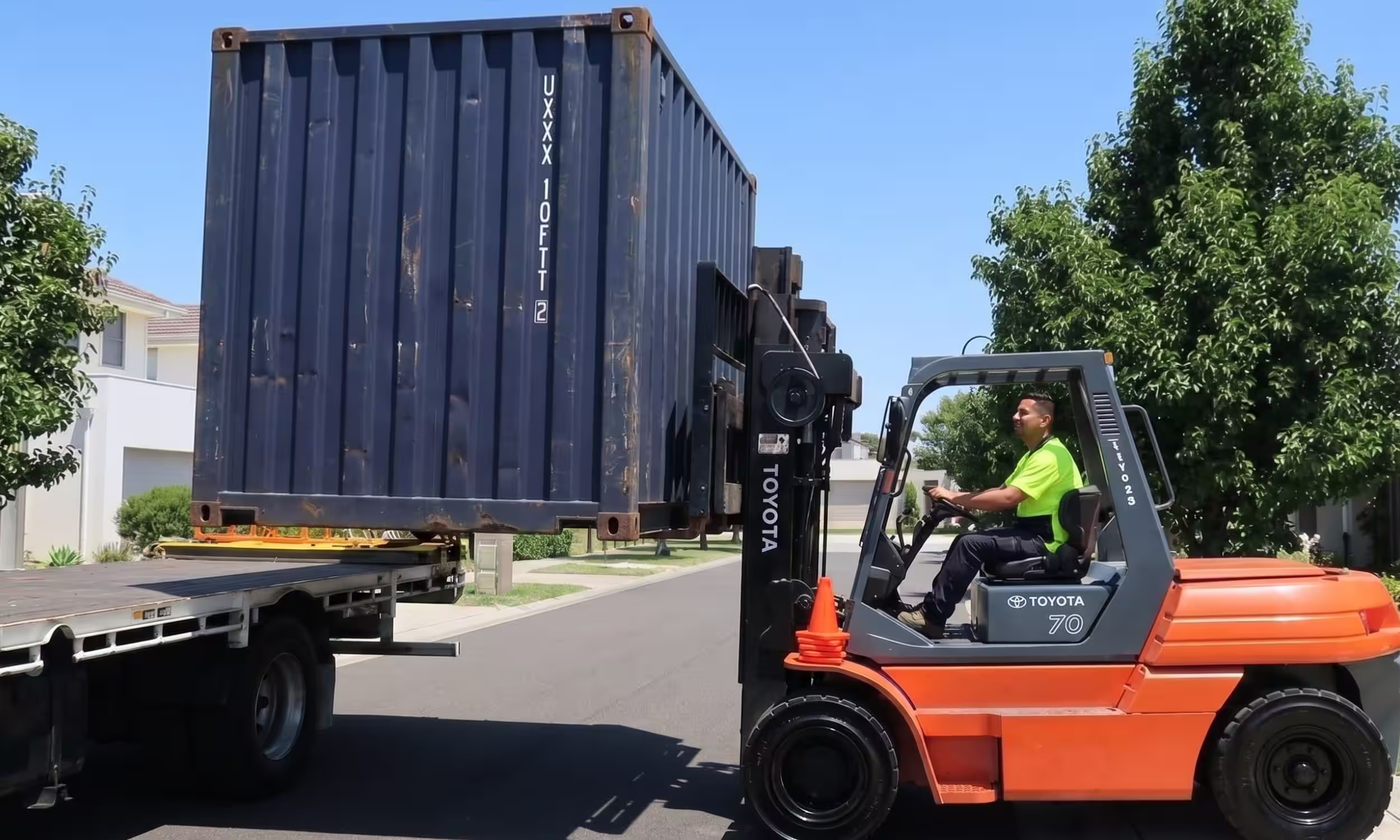 Contenedor de 10 pies siendo cargado por un montacargas hacia un camión